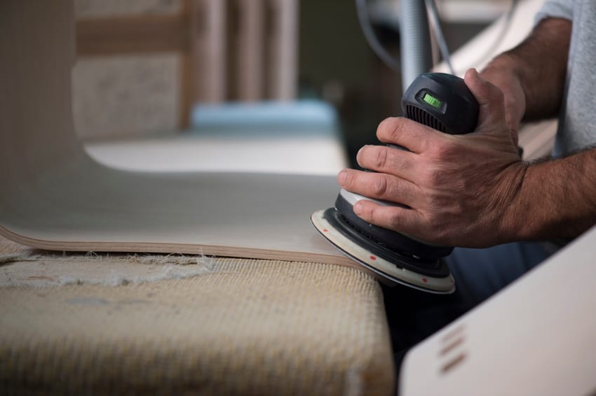 Photo d'une personne ponsant une pièce de bois moulé