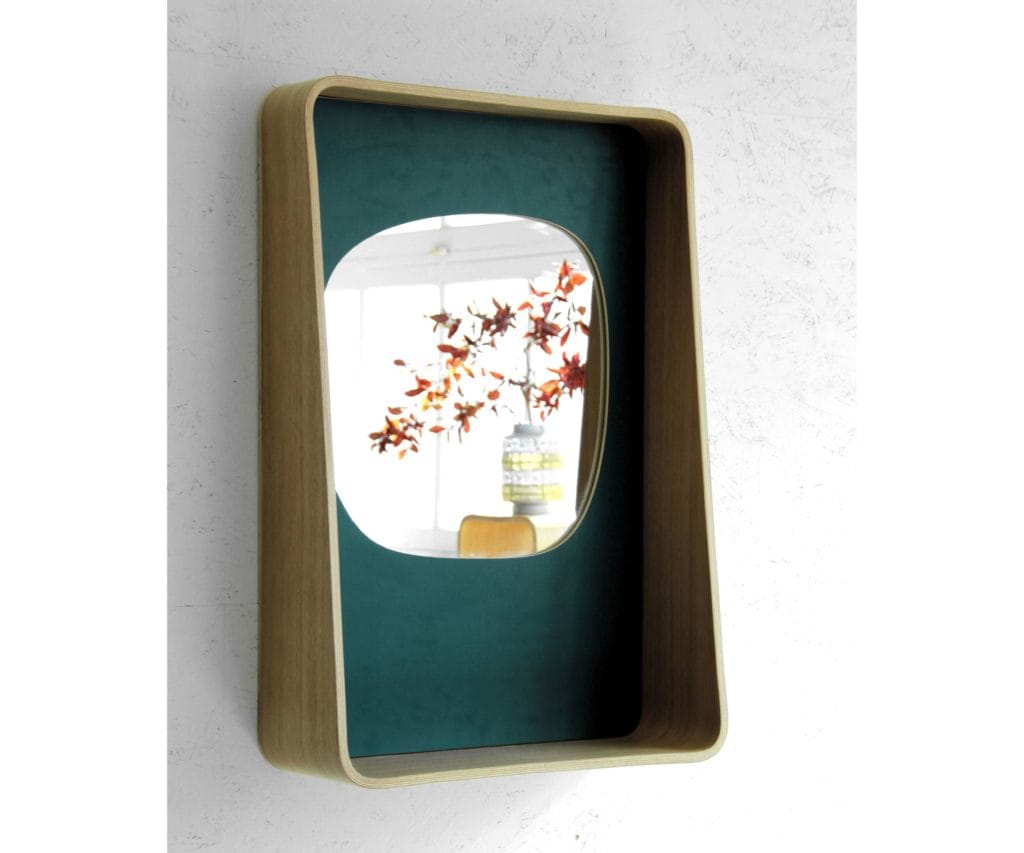 Miroir sur fond vert et entouré de bois moulé