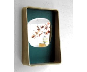 Miroir sur fond vert et entouré de bois moulé