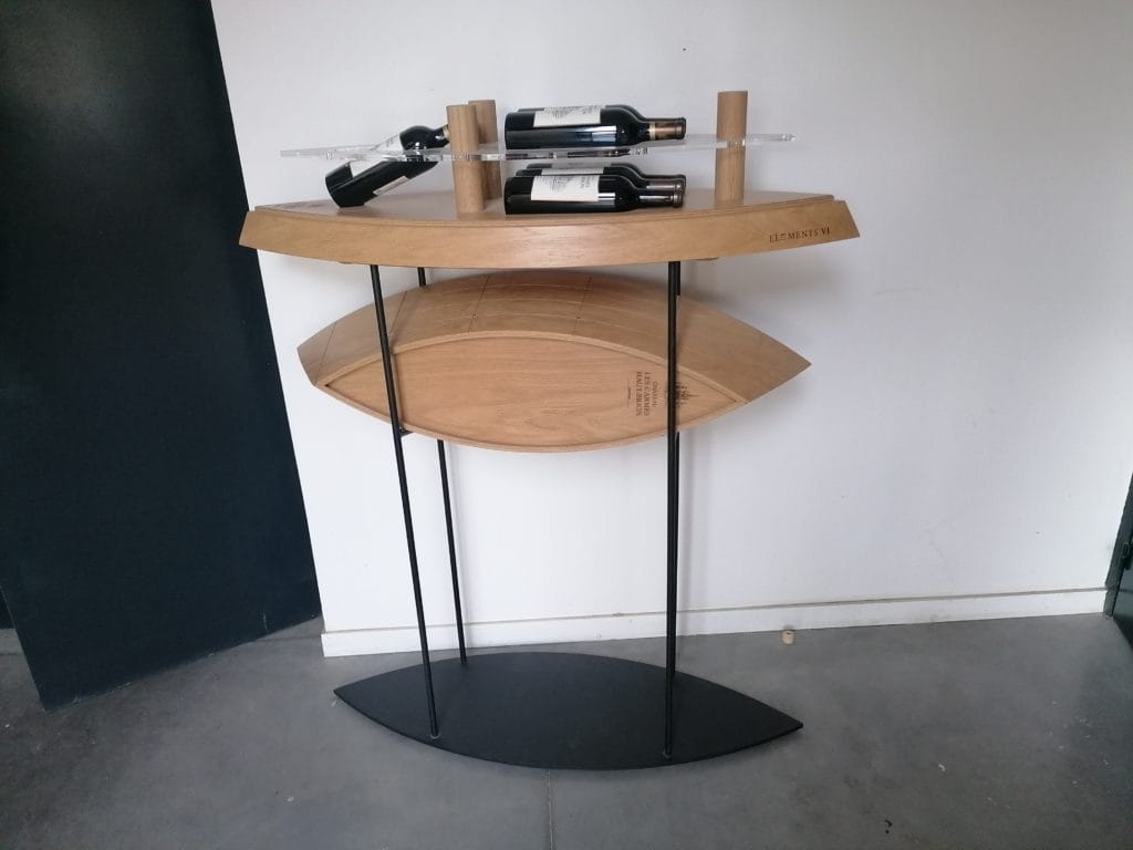 Présentation de bouteilles d'une édition spéciale du Château Les Carmes Haut-Brion dans une caisse en bois multiplis moulé représentant un bateau