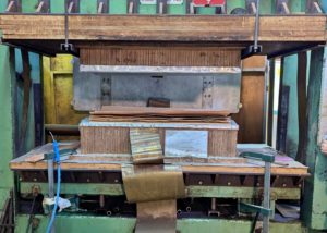 Photo d'une presse poisson matrice en train de mouler une pièce de bois moulé