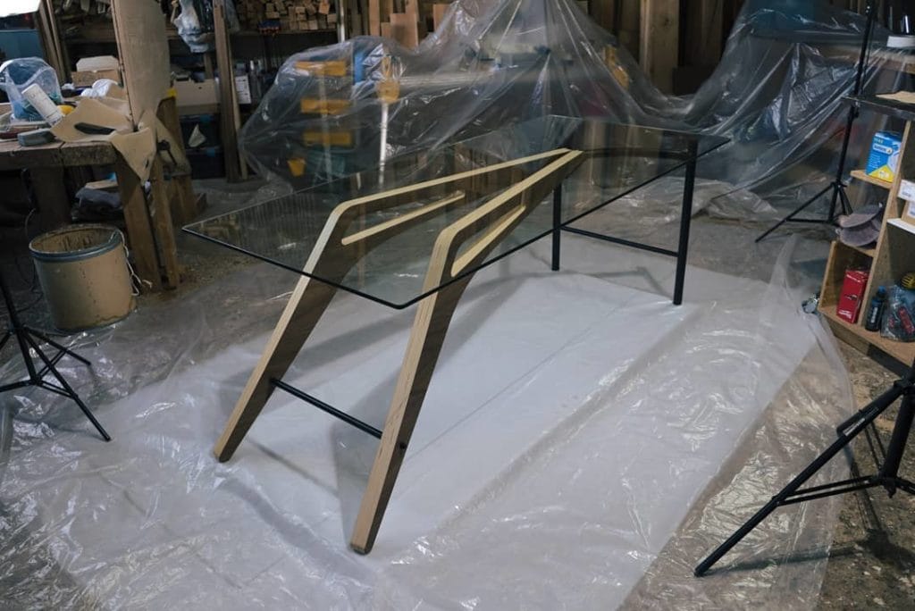 Table en verre avec pieds en bois moulé et pieds en metal